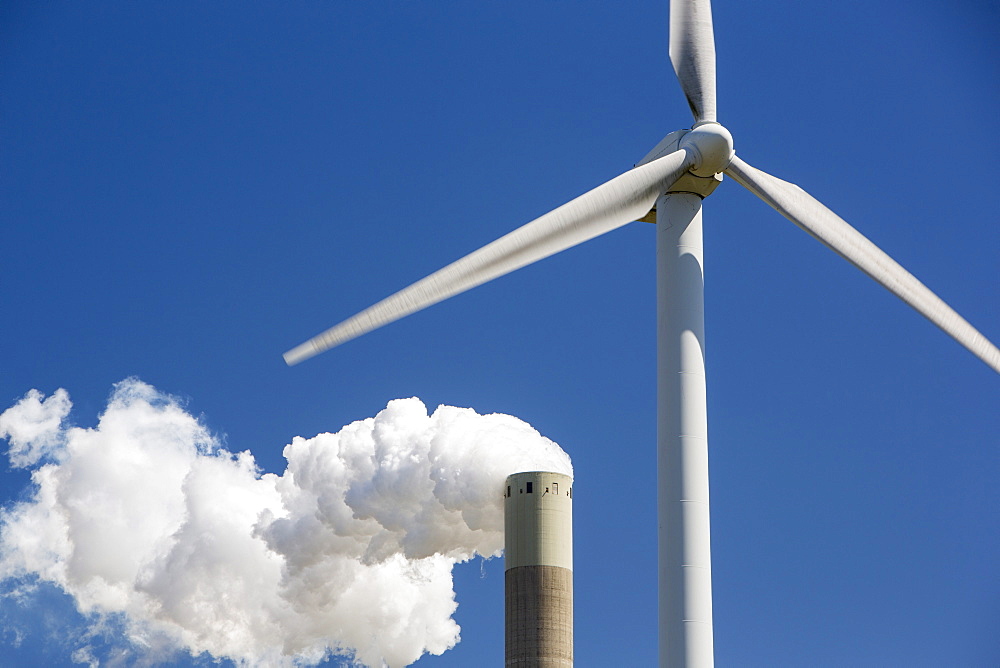 Climate change heaven and hell of a wind turbine with emissions from a coal fired power station in Amsterdam, Netherlands, Europe