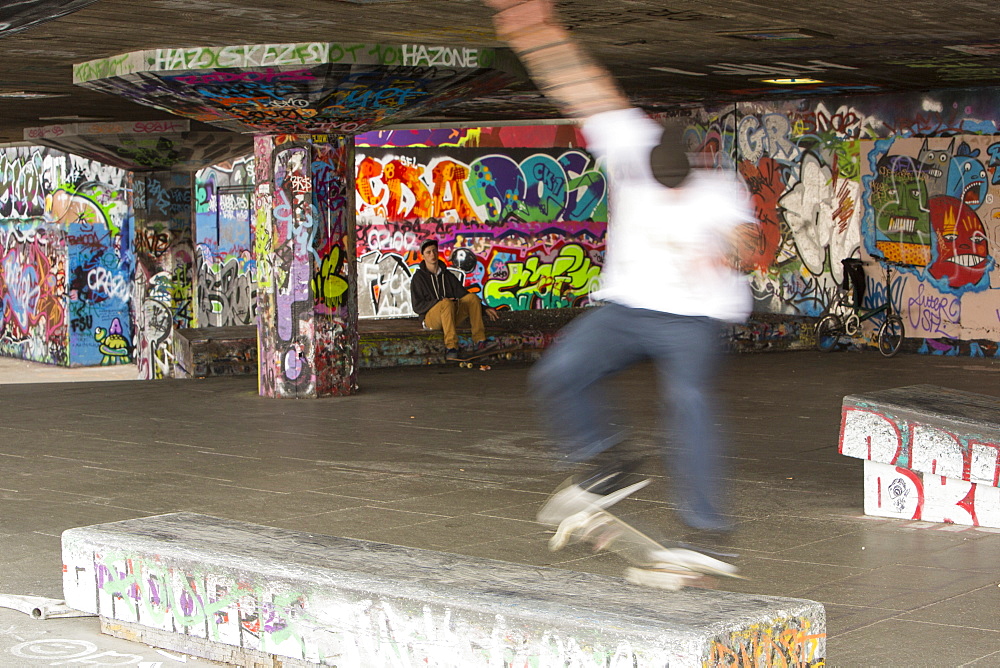 Skateboarders leaping obstacles on London's South Bank, London, England, United Kingdom, Europe