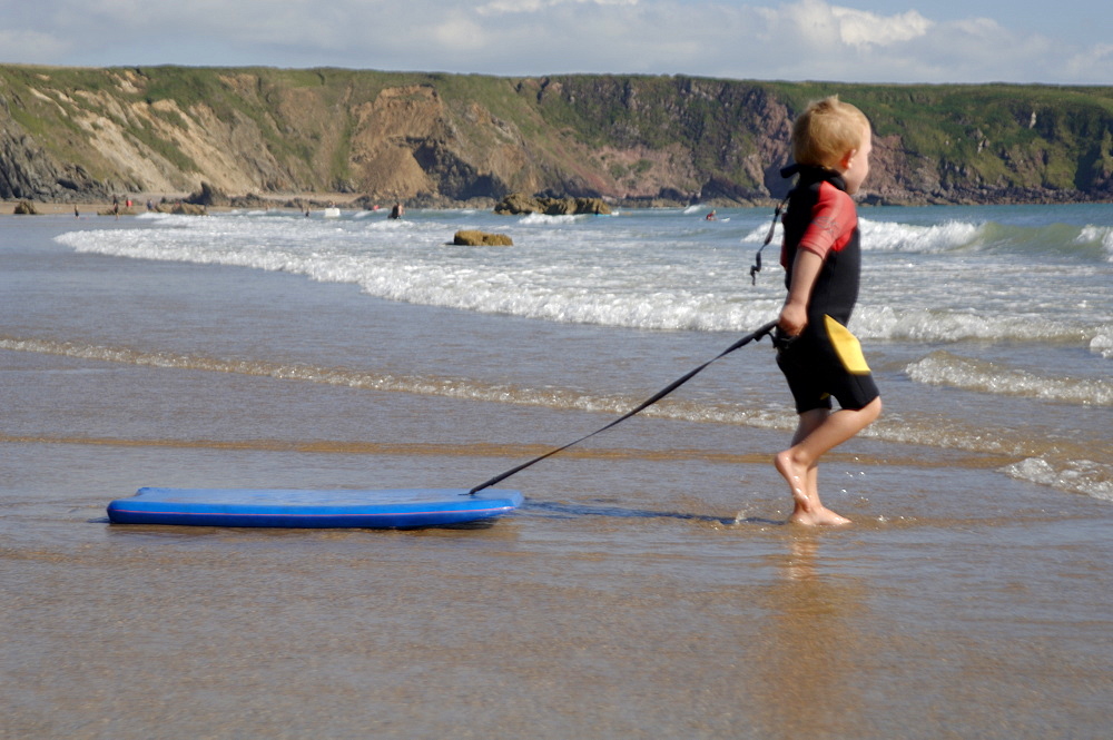 Boy playing in sea with boogie board      (rr)