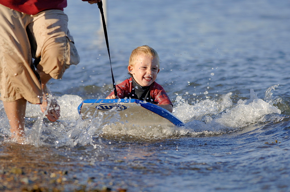 Young boy being towed on boogie board