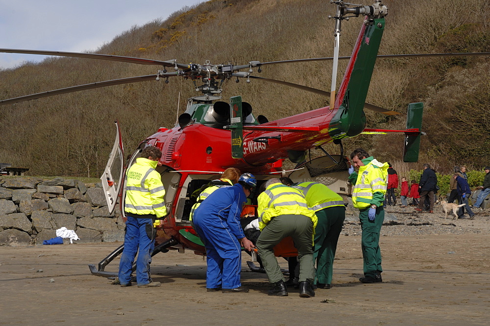 Wales Air Ambulance and crew loading a casualty into helicopter at Solva harbour, Solva, Pembrokeshire, Wales, UK, Europe