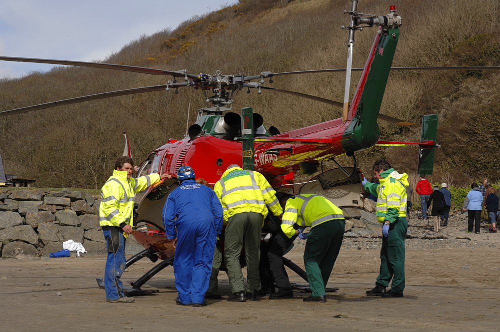 Wales Air Ambulance and crew loading a casualty into helicopter at Solva harbour, Solva, Pembrokeshire, Wales, UK, Europe