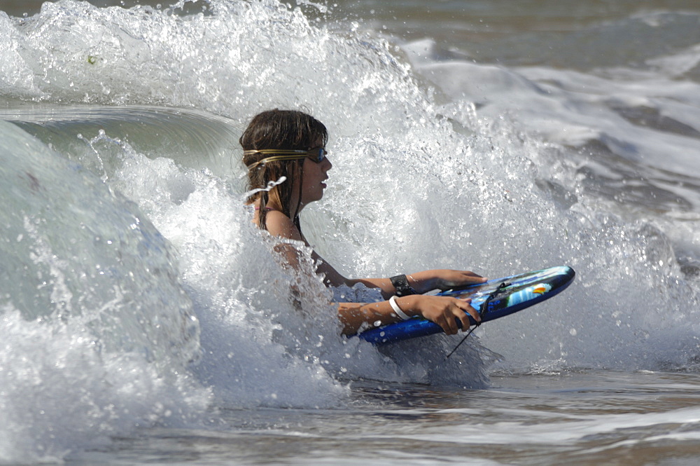 Girl boogie boarding on wave, West Dale beach, Pembrokeshire, Wales, UK, Europe