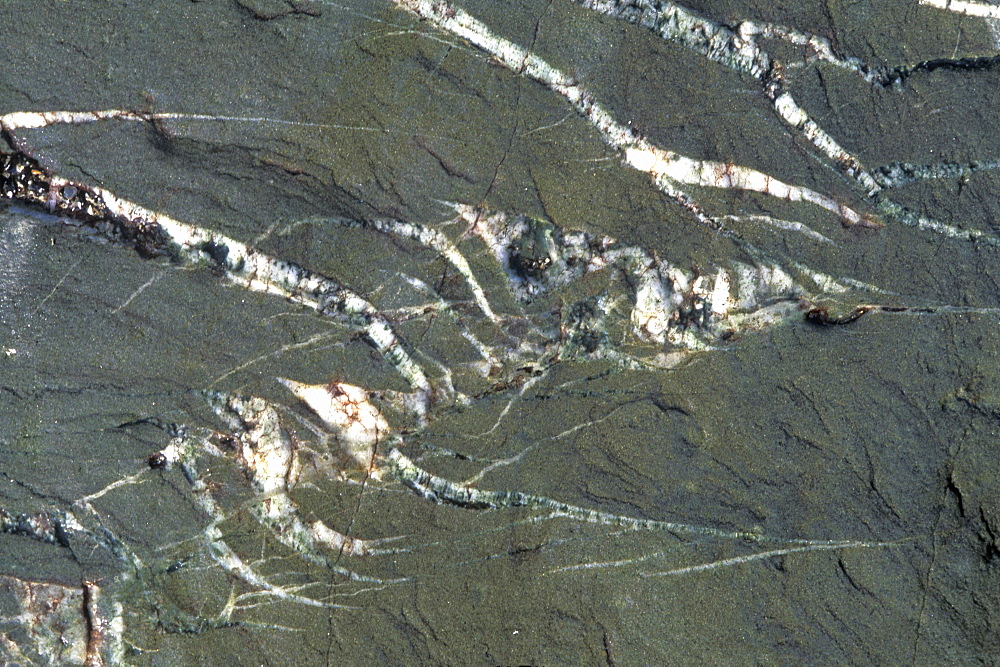 Tension cracks in rock filled with quartz         (rr)