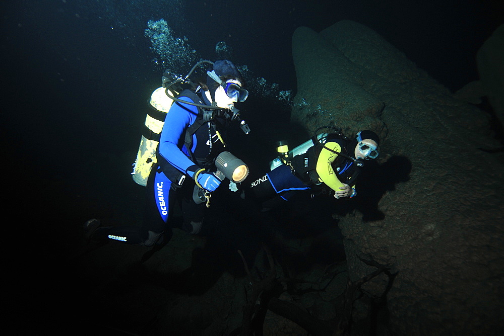 Scuba divers explore underwater cones in cave, Anhumas abyss, Bonito, Mato Grosso do Sul, Brazil, South America