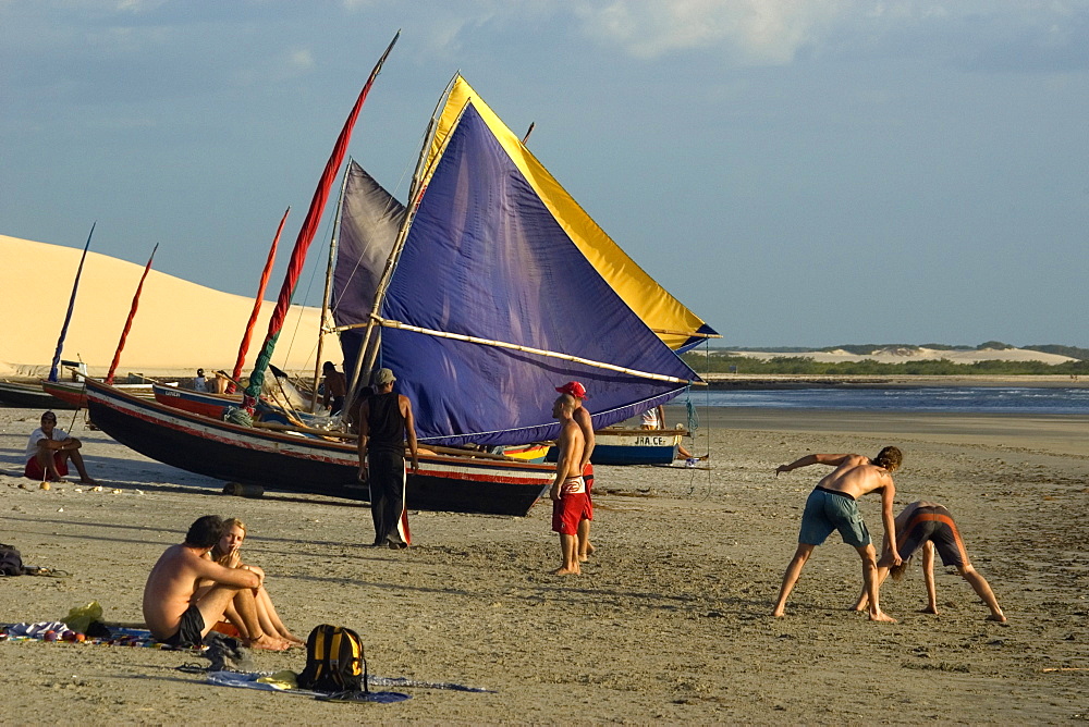 Tourists playing capoeira, traditional Brazilian martial arts and jangadas, typical Brazilian fishing boat, Jericoacoara Beach, Ceara, Brazil, South America