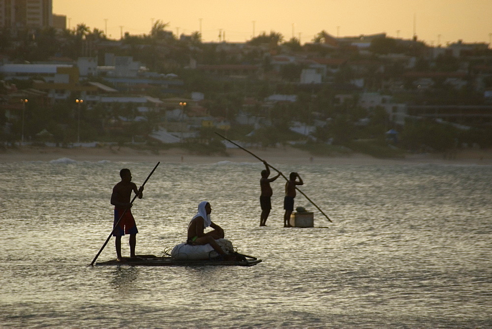 Fishermen in a traditional fishing raft at dusk, Natal, Rio Grande do Norte, Brazil, South America