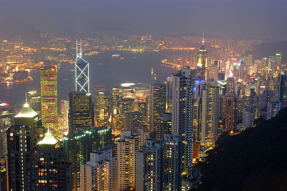 Hong Kong's modern skyline overlooking Victoria harbour and Kowloon peninsula at night, Hong Kong, China, Asia