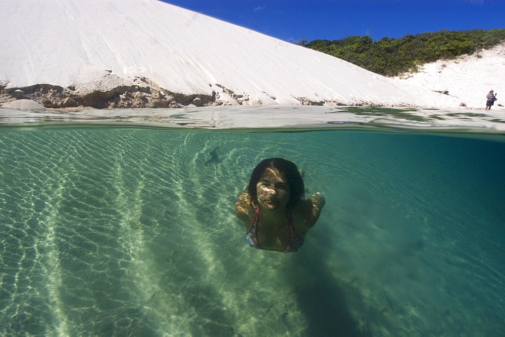 Woman relaxes in a natural rain water pool, Lencois Maranhenses, Maranhao, Brazil, South America