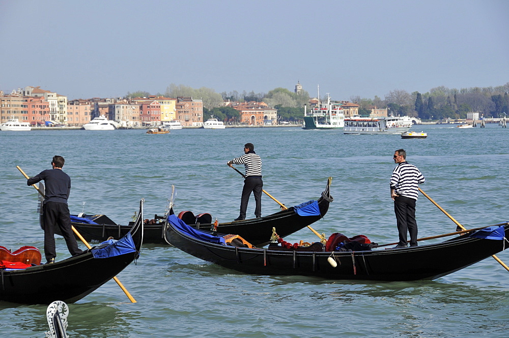 Gondoliers over Venetian lagoon, Venice, UNESCO World Heritage Site, Veneto, Italy, Europe