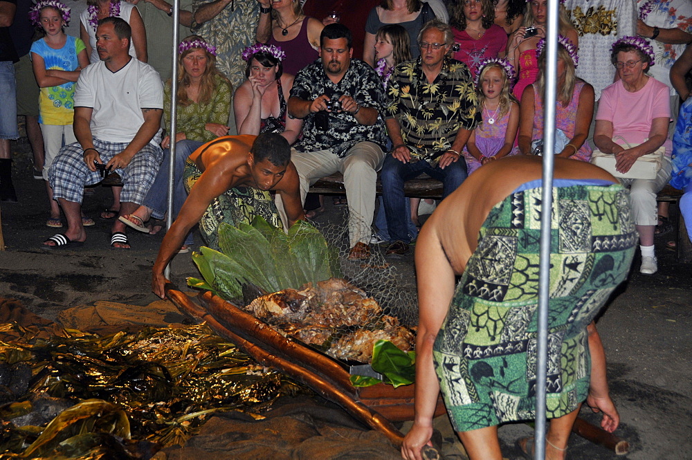 Men remove slow cooked pork from the earth and stone oven (imu) viewed by guests, Kona Village Resort Luau, Kailua-Kona, Big Island, Hawaii, United States of America, Pacific