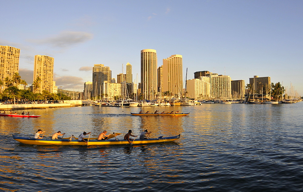 Young canoe rowers enjoy paddling near Ala Moana harbour at dusk, Waikiki, Oahu, Hawaii, United States of America, Pacific