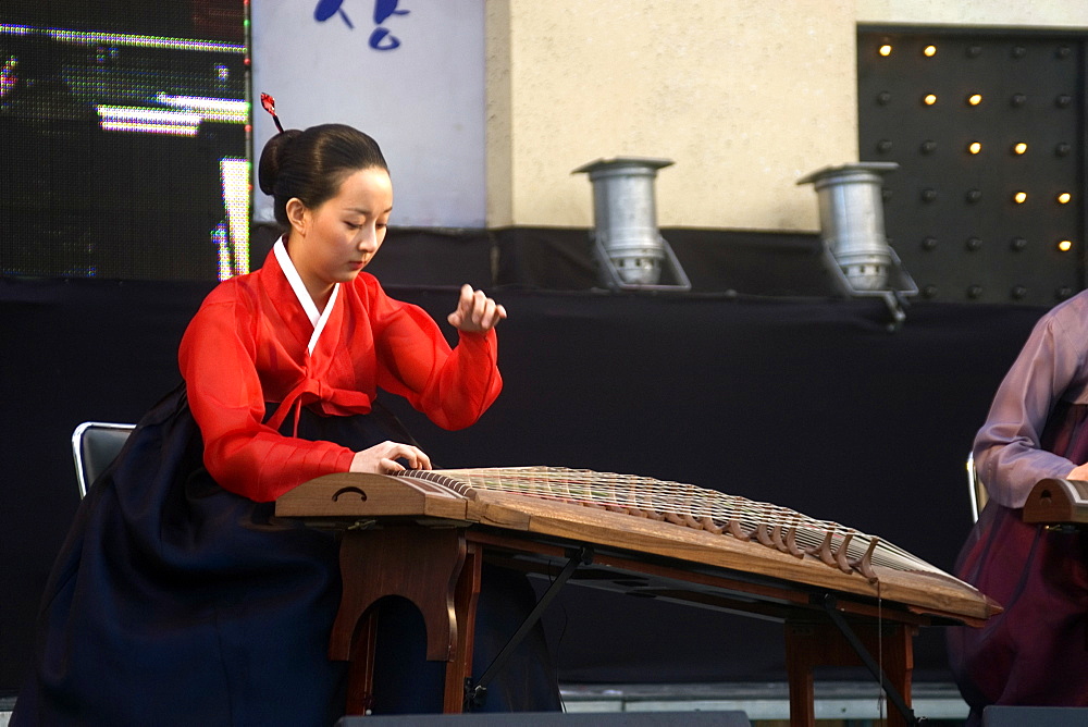 Korean woman plays a Gayageum, a traditional zither like musical instrument at the Peace festival, Geoje-Do, South Korea, Asia