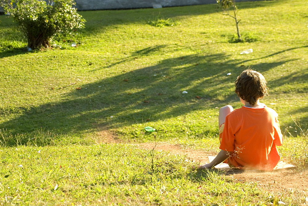 Boy slides on cardboard at Sunset Square, Sao Paulo, Brazil, South America