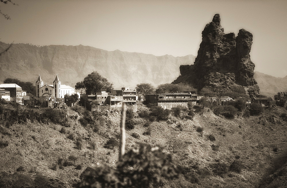 03/04/2009. The town of Picos on Sao Tiago Island of the Cape Verdes. Landscape view of volcanic formations and residential buildings with church. . Praia, Picos town, Sao Tiago Island. Cape Verde