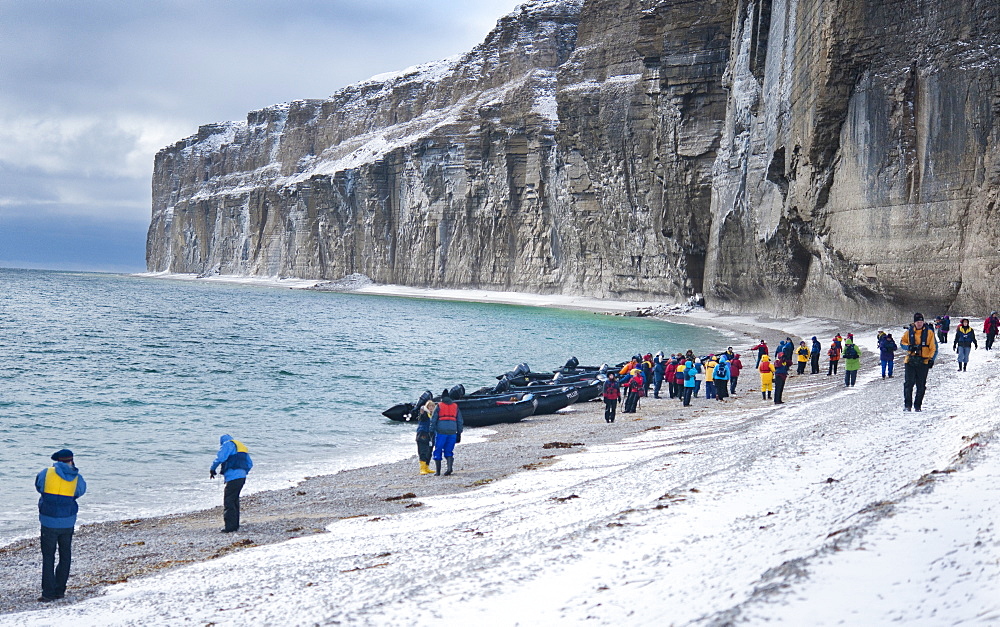 Tourist standing on snow covered arctic beach. Akpatok Island, Quebec, Nunavik, Canada, North America