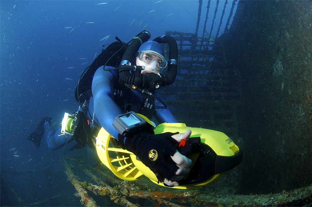 Mixed gas rebreather diver using scooter for mobility around  wreck.  Red Sea.