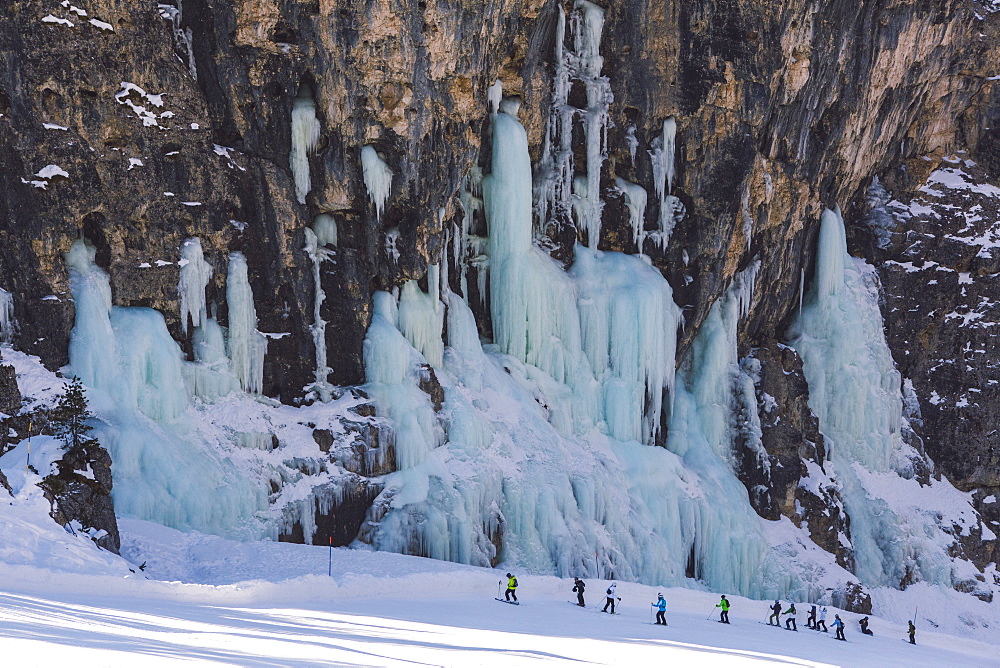 Skiers underneath the frozen waterfall, Hidden Valley ski area, Lagazuoi, Armentarola 101, Ski piste, Dolomites, UNESCO World Heritage Site, South Tyrol, Italy, Euruope