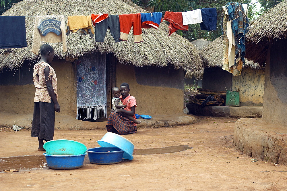 Nessled amongst the mud huts, girls have finnished cleaning the clothes and have hung them up to dry.  Gulu, Uganda. Gulu Town, Uganda, East Africa