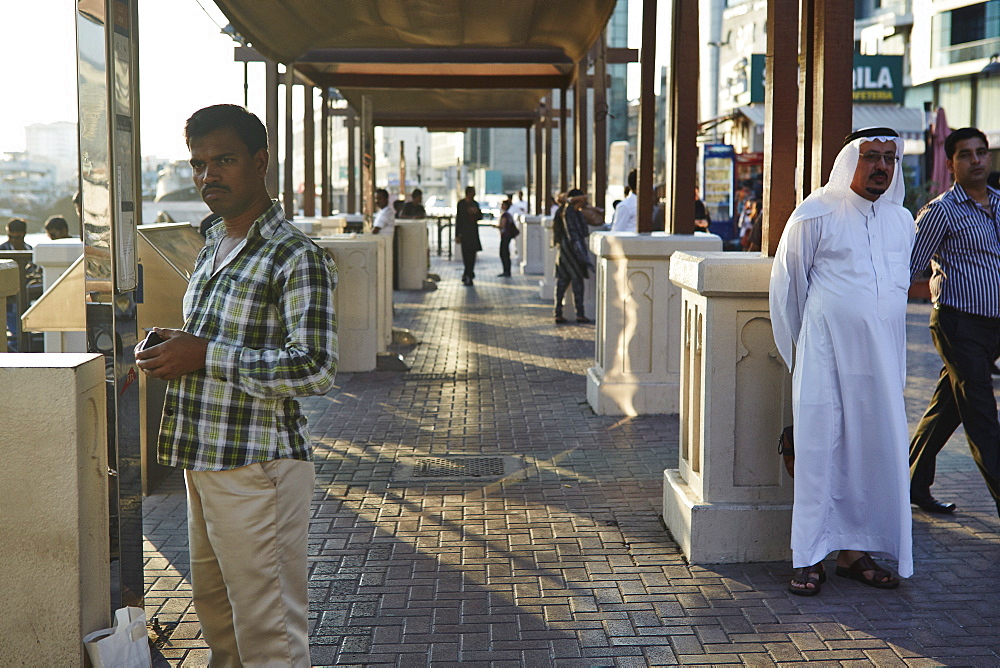 Locals meander along waterside at sunset, Dubai Creek, Dubai, United Arab Emirates, Middle East.