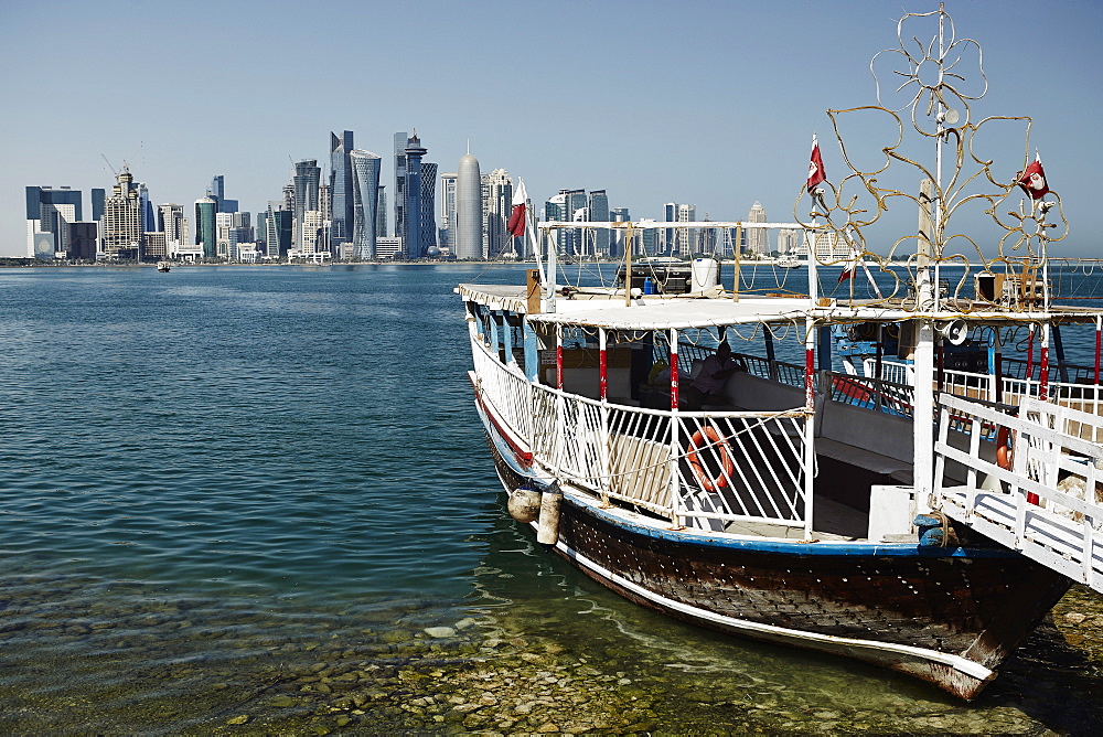 Downtown Doha with its impressive skyline of skyscrapers with authentic dhows in the bay, Doha, Qatar, Middle East