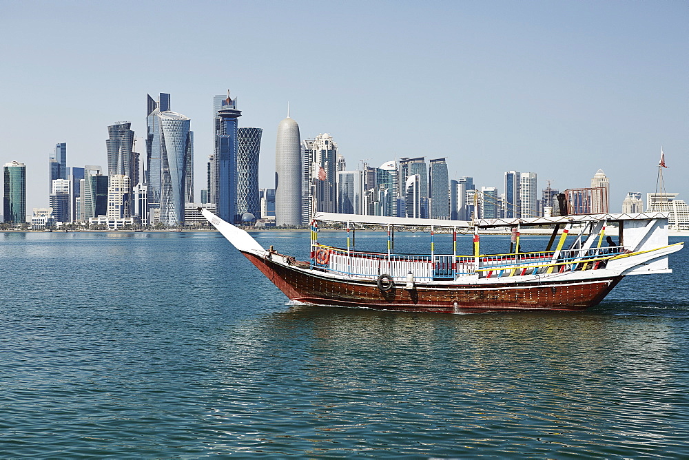 Downtown Doha with its impressive skyline of skyscrapers with authentic dhows in the bay, Doha, Qatar, Middle East