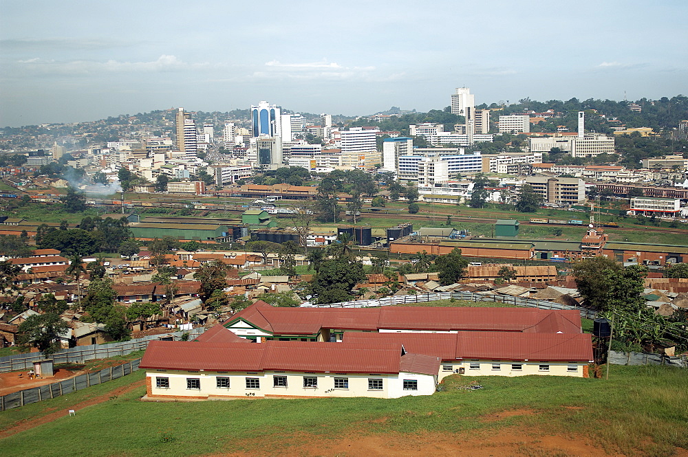 A view of the Kampala skyline with it's rail track and industrial buildings in the foreground.  This is Kampala's Central Business District. Kampala, Uganda, East Africa