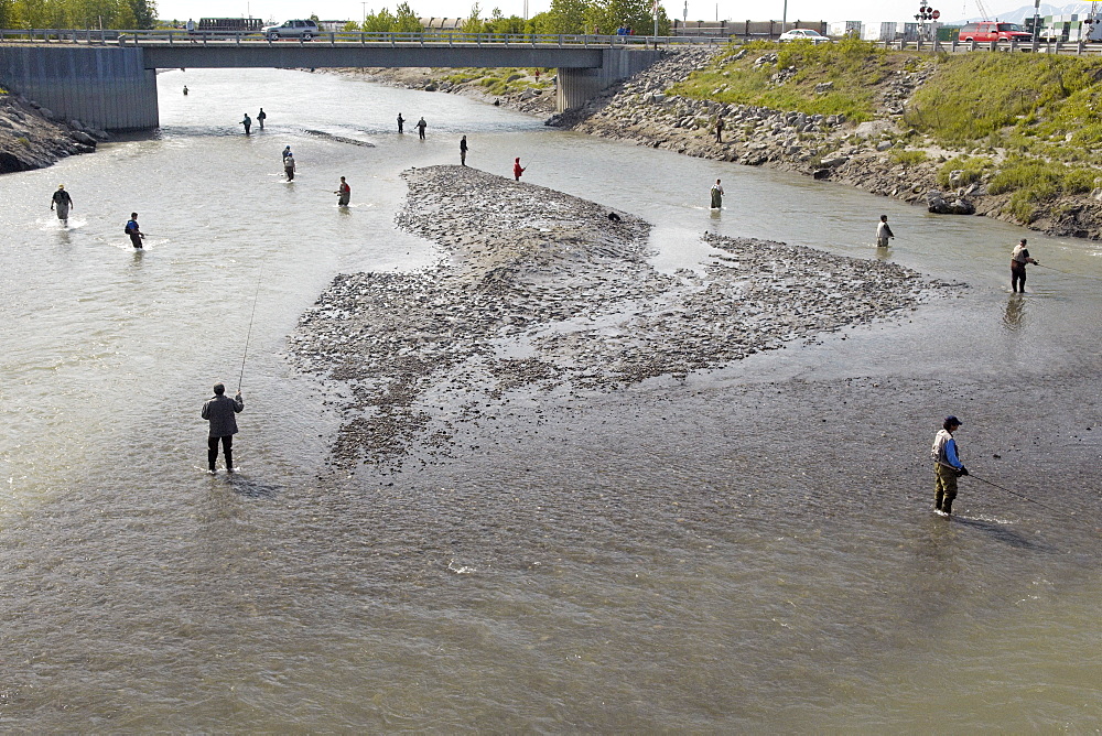 Fishing for Chinook Salmon, the fishermen of Anchorage come out in their droves to land a catch in the shallow setury of Ship Creek, downtown Anchorage, Alaska. Anchorage, Alsaka, USA