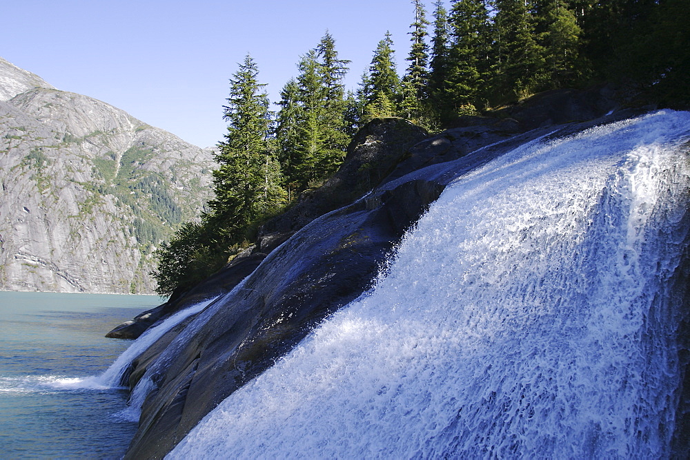 Glacier meltwater forms a small waterfall in Tracy Arm in southeast Alaska, USA.