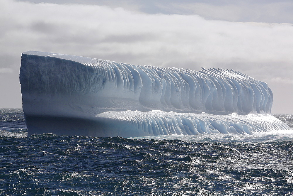 Huge intensely blue bench iceberg adrift in Antarctica.