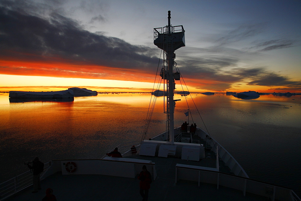 The National Geographic Endeavour cruises the Weddell Sea through icebergs at midnight near the Antarctic Peninsula.