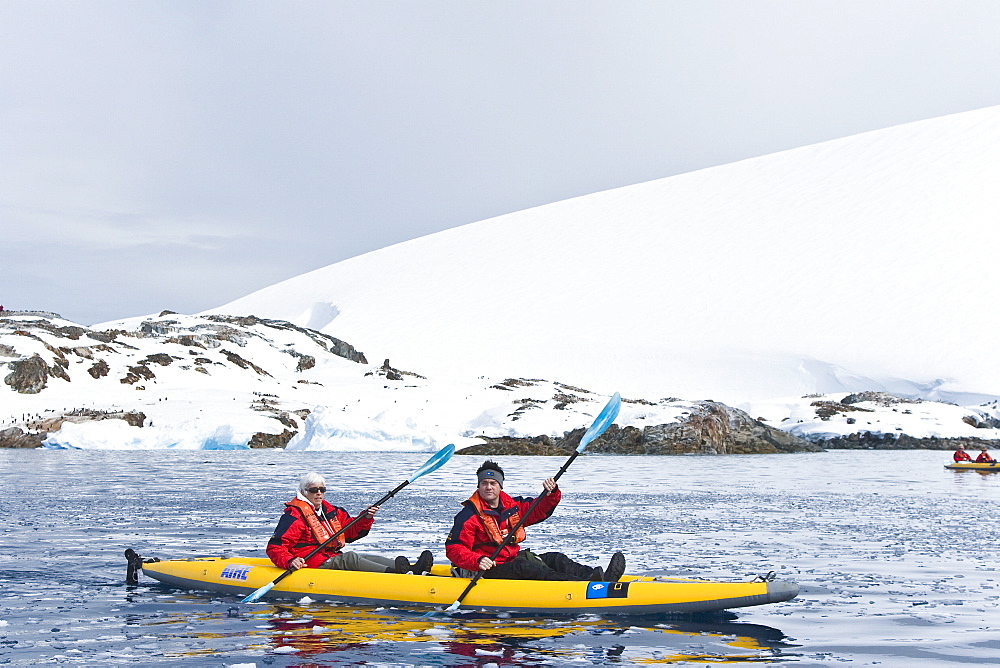 Lindblad Expeditions guests kayaking at Petermann Island in Antarctica as part of expedition travel. NO MODEL RELEASES FOR THIS IMAGE.