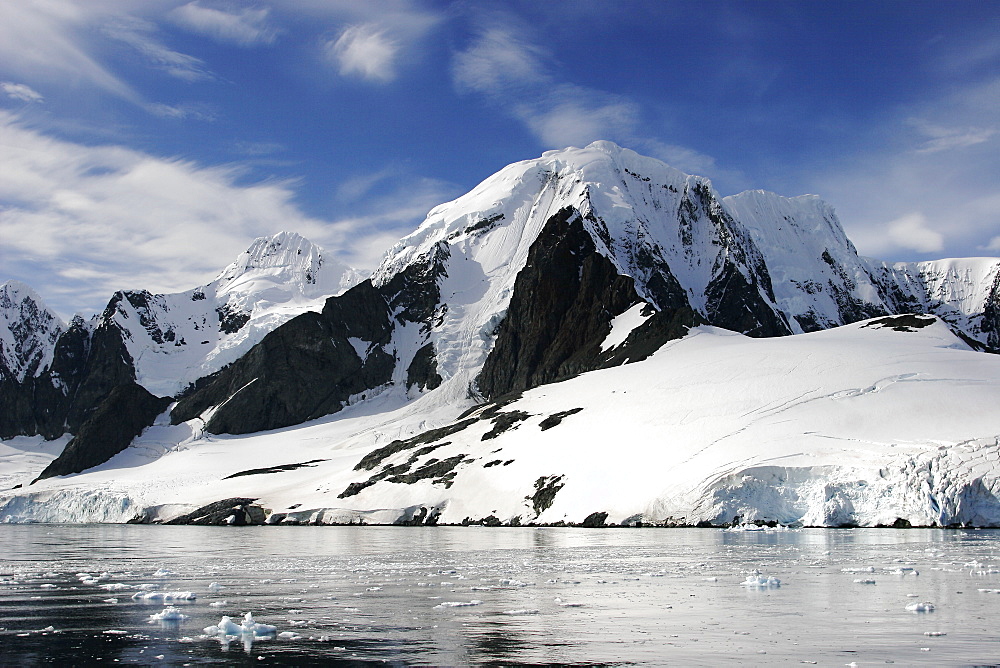 Reflections and snow covered mountains in Lemaire Channel in Antarctica.