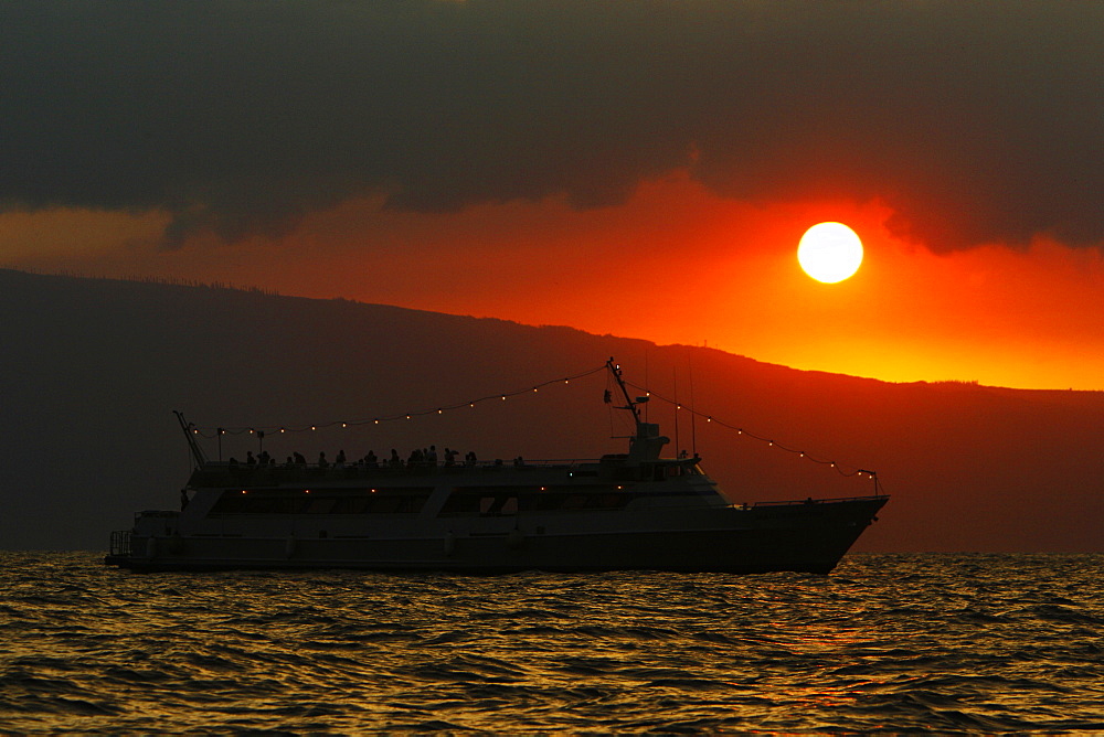 Sunset on tourist boat across the AuAu Channel between Maui and Lanai, looking west with Lanai in the background. Maui, Hawaii, USA.