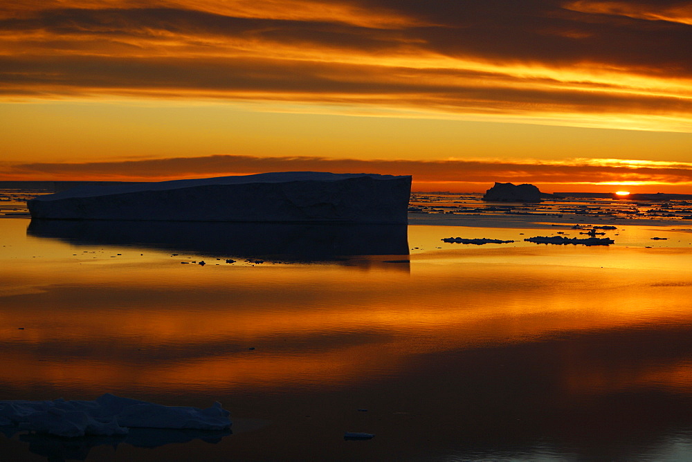 Sunset on fresh sea ice and tabular icebergs in the Weddell Sea, Antarctica.