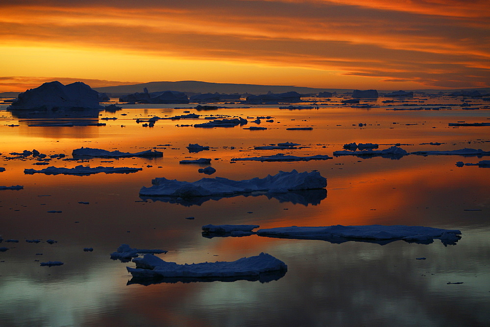 Sunset on fresh sea ice and tabular icebergs in the Weddell Sea, Antarctica.