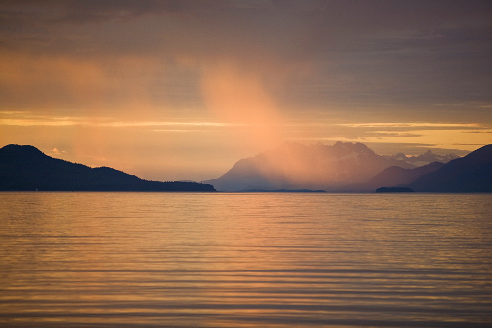 Sunset illuminating rain shower in Stephen's Passage near Juneau, Southeast Alaska, USA. Pacific Ocean.