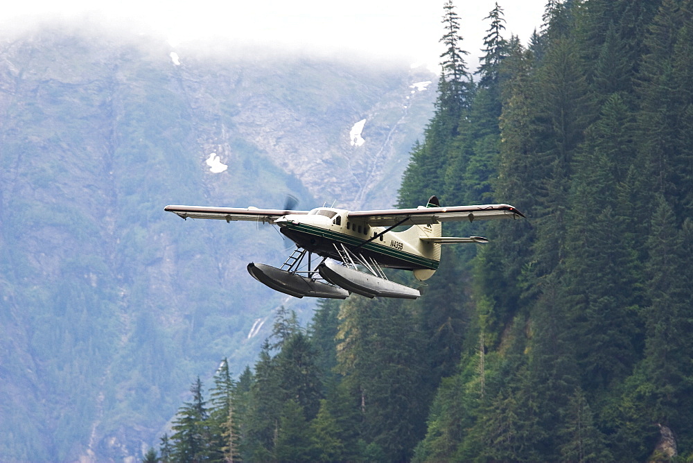 Flightseeing float planes in and out of the "Punchbowl" rock formation in Kynoch Inlet in Misty Fjords National Monument in Southeast Alaska, USA. Pacific Ocean.