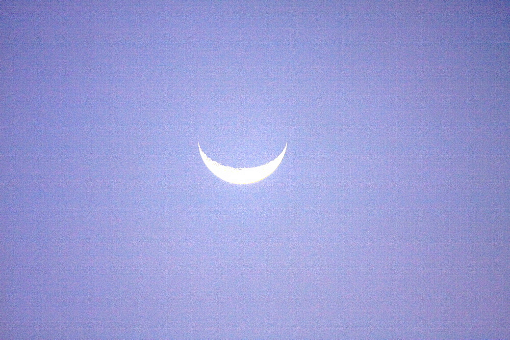 Crescent moon setting under the light of a Baja Sunset, Baja California Sur, Mexico.