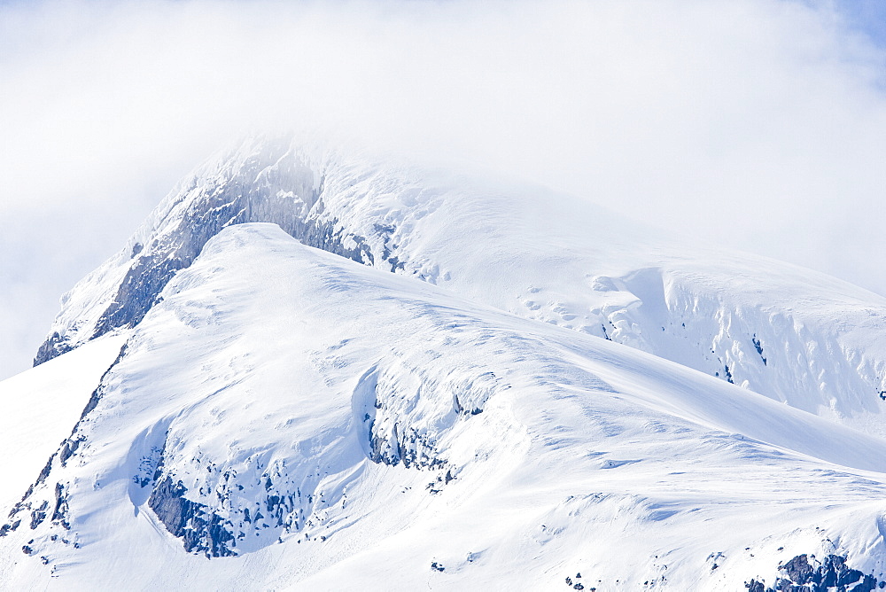 Misty cloud shrouded mountain peak on Baranof Island in Southeast Alaska in the late springtime, USA, Pacific Ocean.