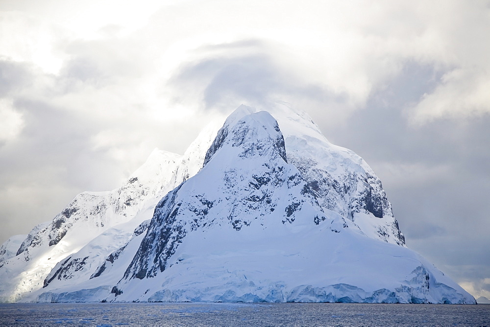 The Lindblad Expedition ship National Geographic Explorer transits Lemaire Channel in late evening light on the west side of the Antarctic peninsula in Antarctica