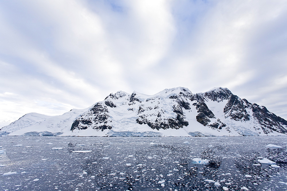 The Lindblad Expedition ship National Geographic Explorer transits Lemaire Channel in late evening light on the west side of the Antarctic peninsula in Antarctica