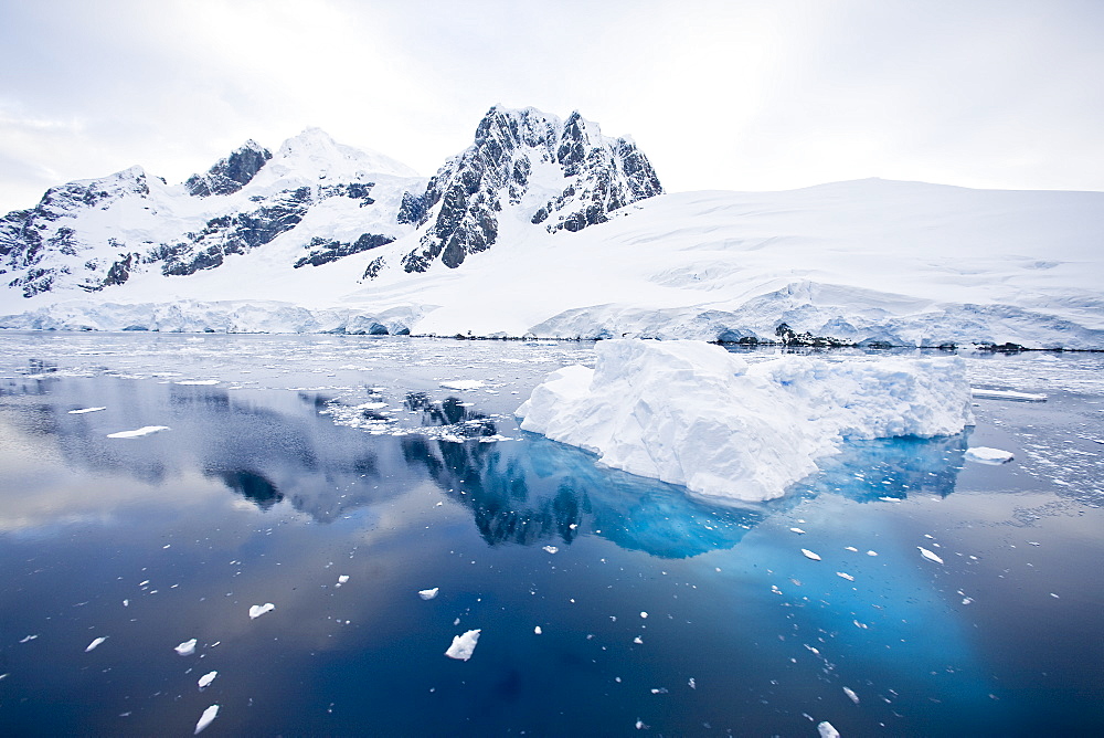 The Lindblad Expedition ship National Geographic Explorer transits Lemaire Channel in late evening light on the west side of the Antarctic peninsula in Antarctica