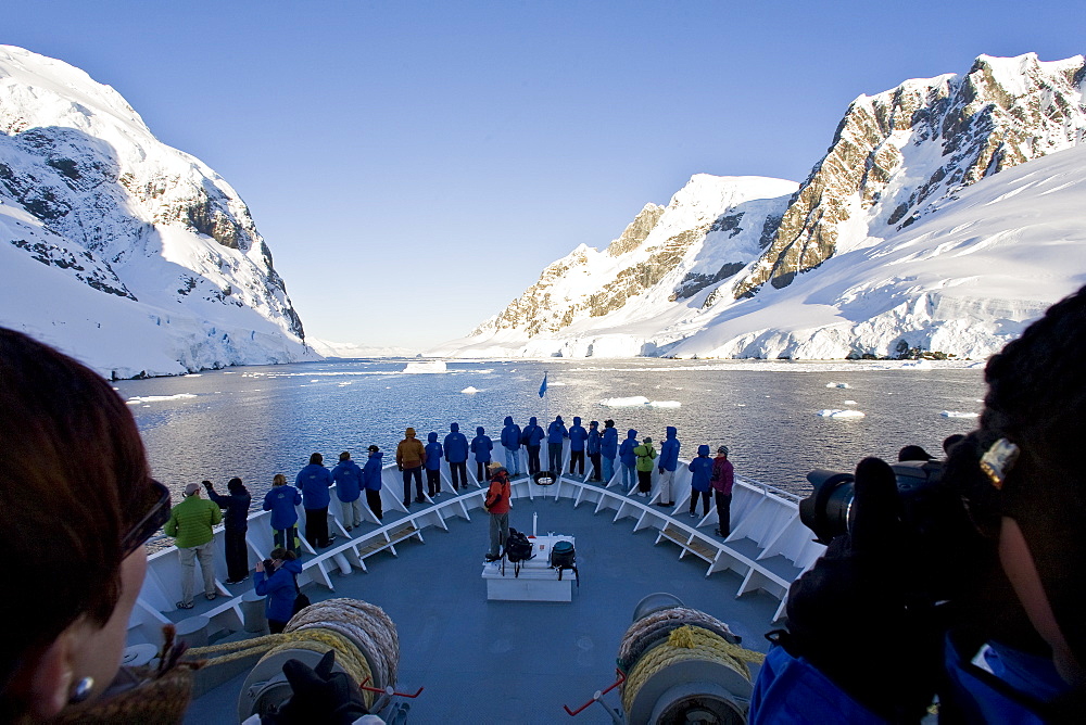The Lindblad Expedition ship National Geographic Explorer transits Lemaire Channel in late evening light on the west side of the Antarctic peninsula in Antarctica