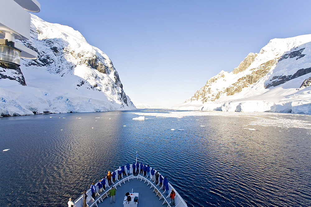 The Lindblad Expedition ship National Geographic Explorer transits Lemaire Channel in late evening light on the west side of the Antarctic peninsula in Antarctica