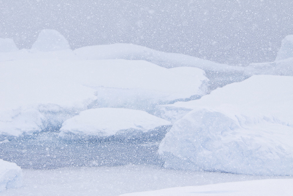 Heavy storm clouds and ice choked waters surround Petermann Island. Petermann Island is a small island just off the west side of the Antarctic Peninsula of Antarctica