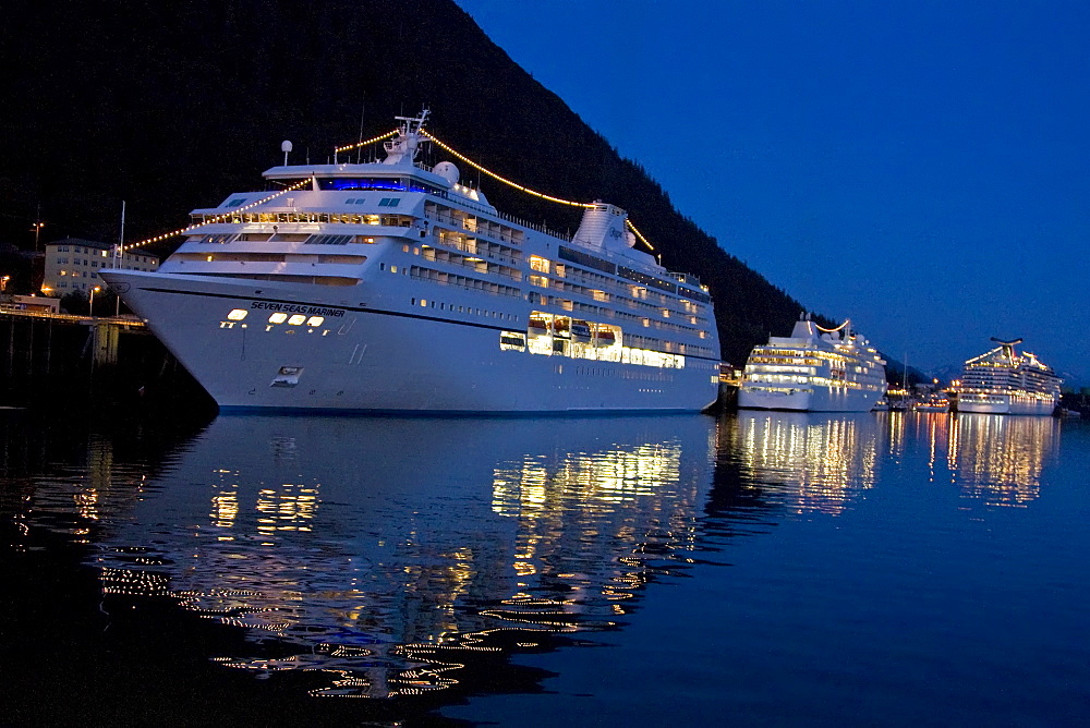 Cruise ships line the docks after sunset in downtown Juneau in Southeast Alaska, USA. Pacific Ocean.