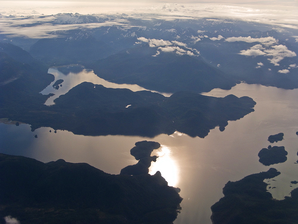 Low clouds and dramatic light on a commercial flight between Sitka and Juneau in Southeast Alaska, USA. Pacific Ocean.