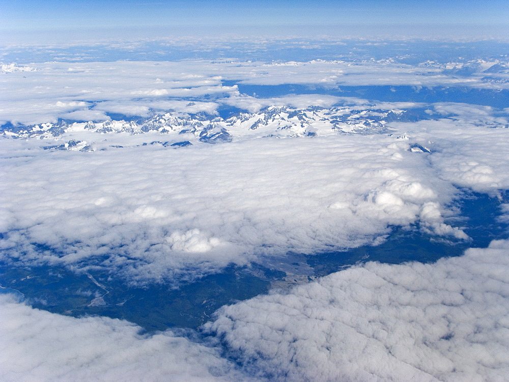 Aerial views of snow-capped mountains, ice fields, and glaciers on a commercial flight from Juneau to Anchorage Alaska, USA, Pacific Ocean