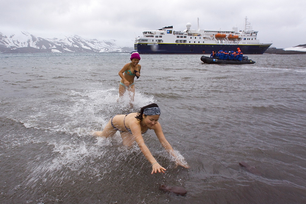 Guests from the Lindblad Expedition ship National Geographic Explorer lay in the relatively warm waters of the caldera at Deception Island, South Shetland Islands, Antarctica